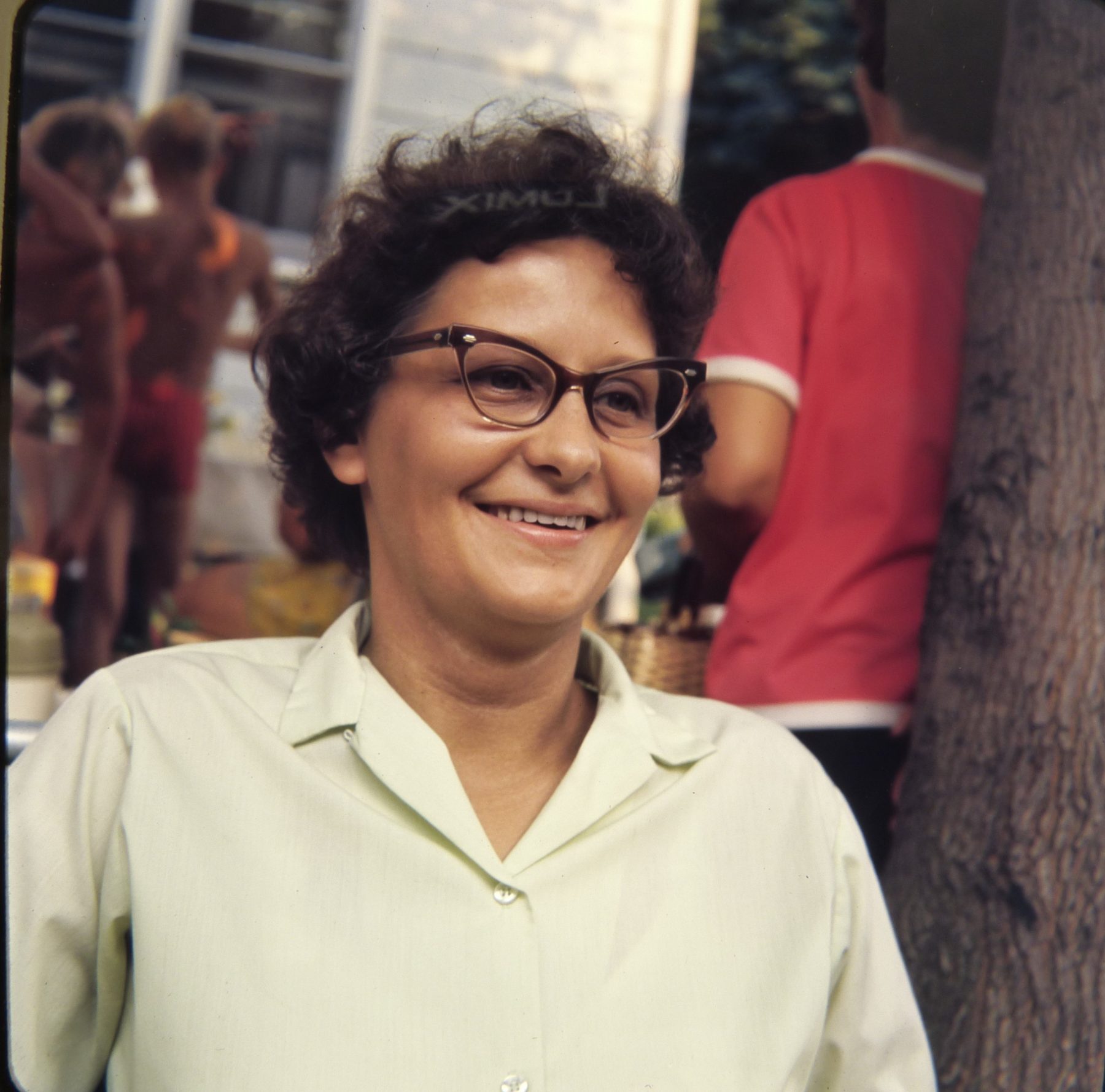 A smiling woman at a backyard gathering