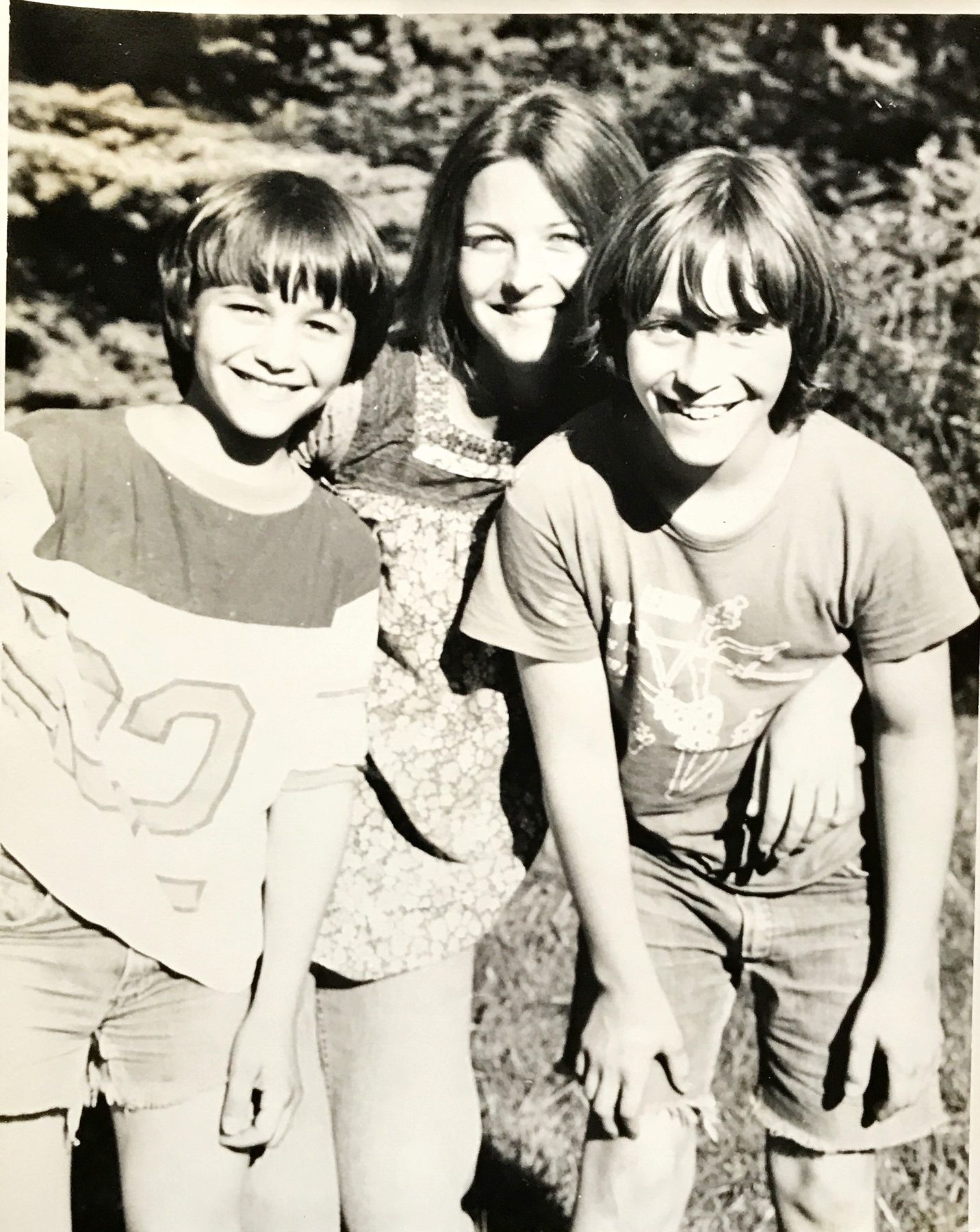 Three kids grinning in the sun