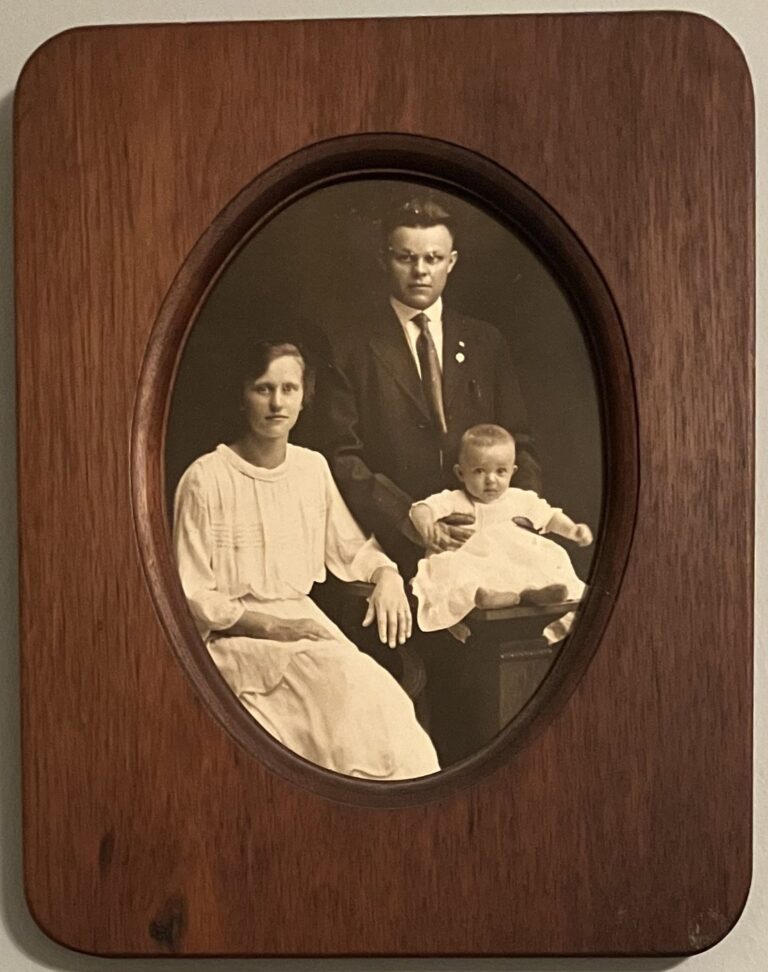 Early studio portrait of George and Anna with a baby, in an oval frame